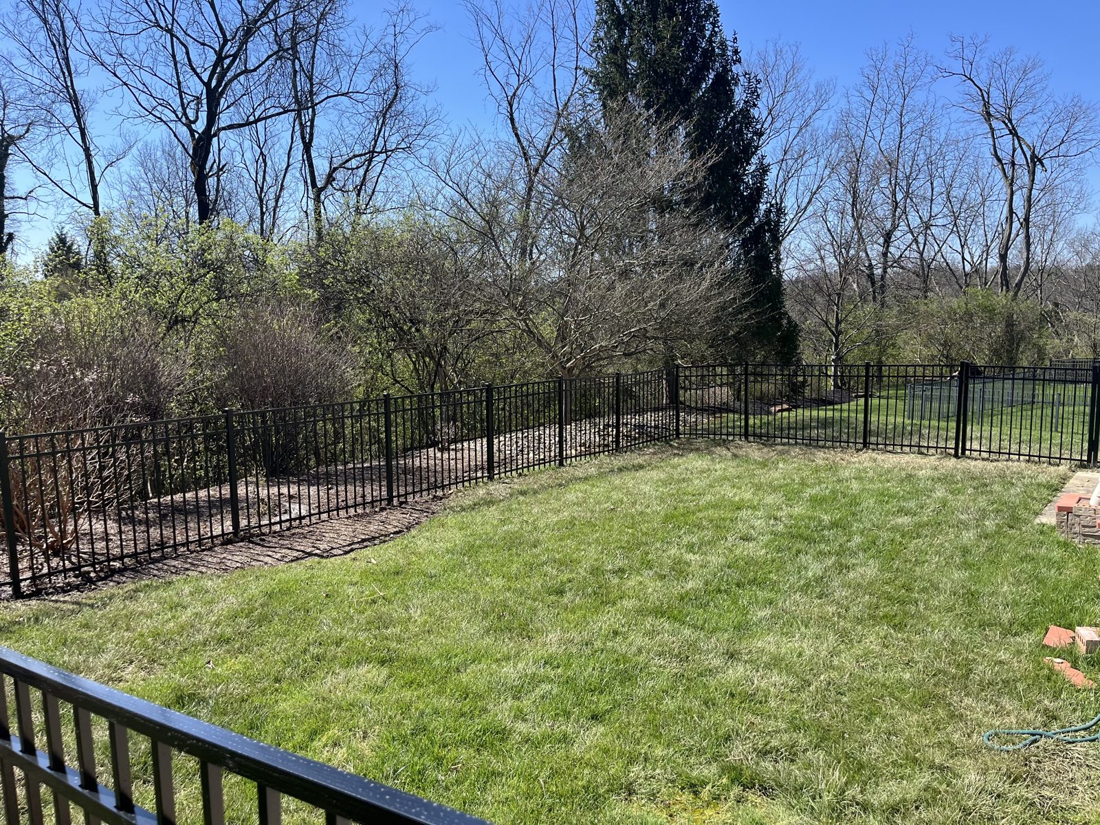 Black aluminum fence along a sloped Cincinnati yard
