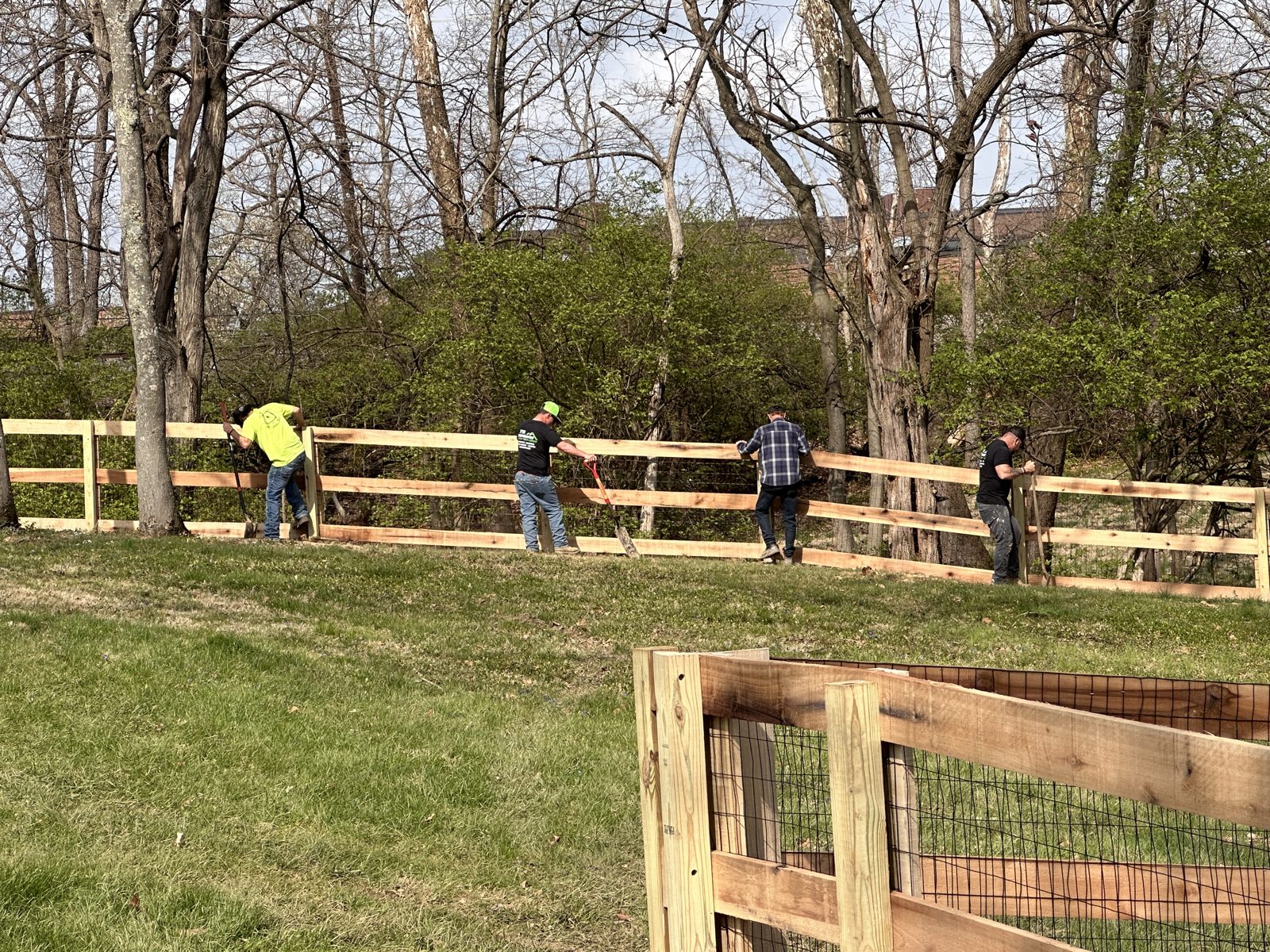 Heartwood crew installing a split rail fence together