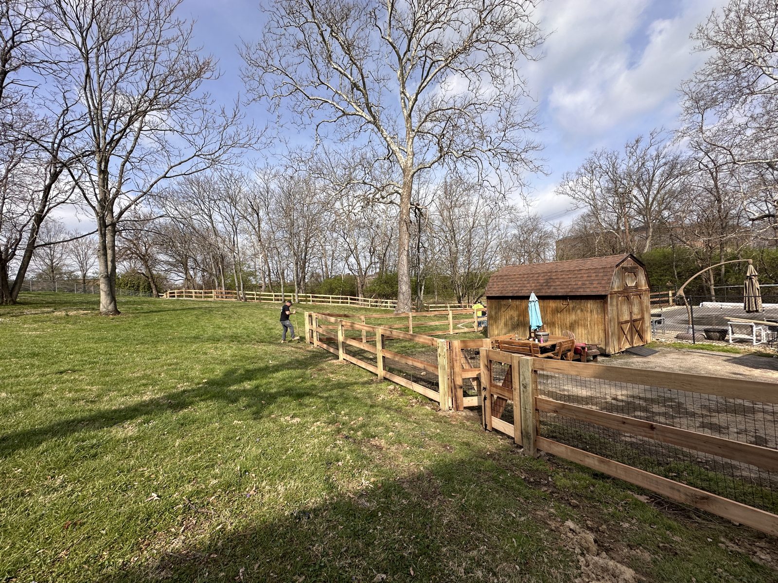 Split rail and wire fence near a garden shed