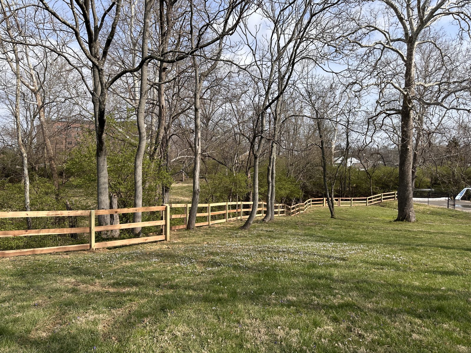 Split rail fence with wire along a wooded lot