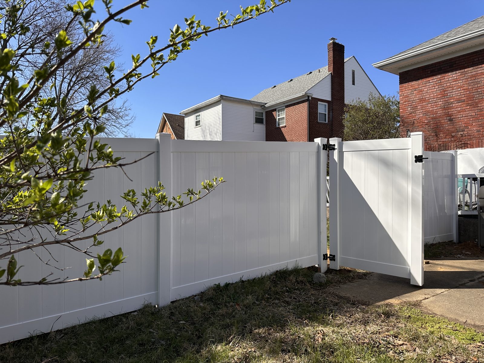 White vinyl privacy fence with driveway gate