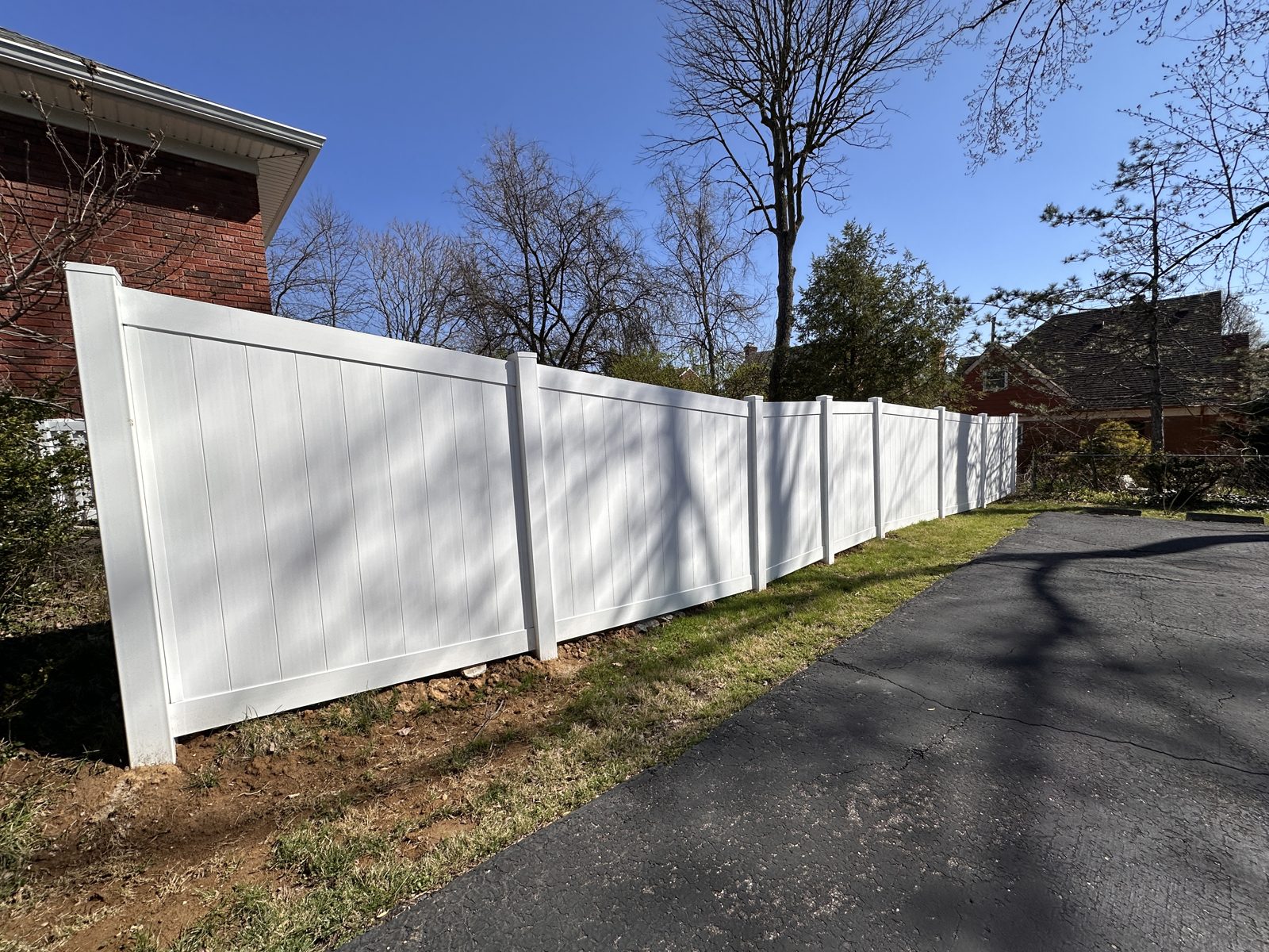 White vinyl privacy fencing along a residential street