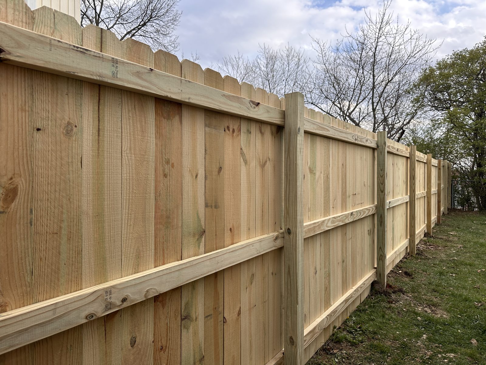 Wood privacy fence behind a brick ranch home