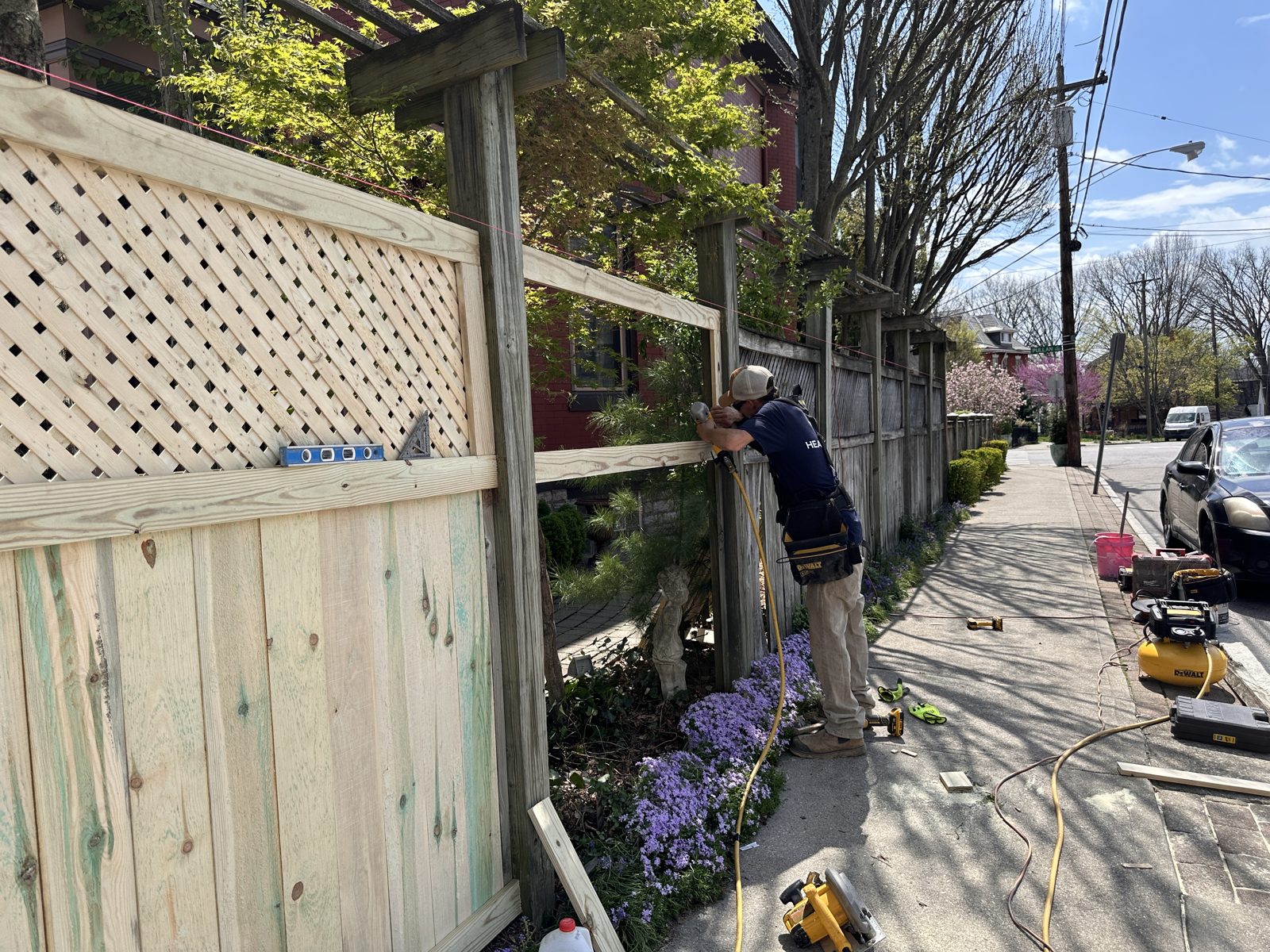 Heartwood crew member installing a lattice-top wood fence