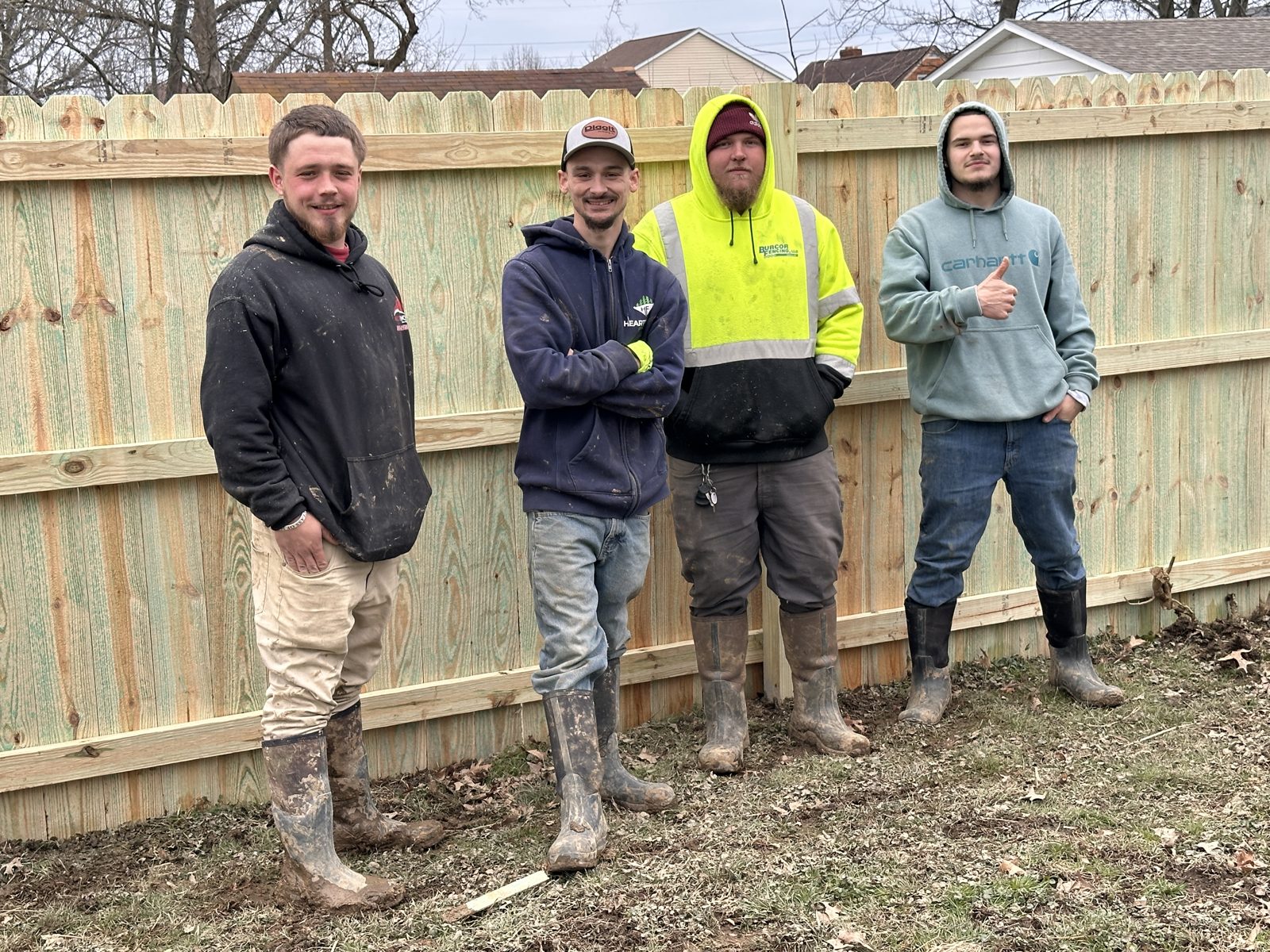 Heartwood Fence crew posing by a completed wood privacy fence