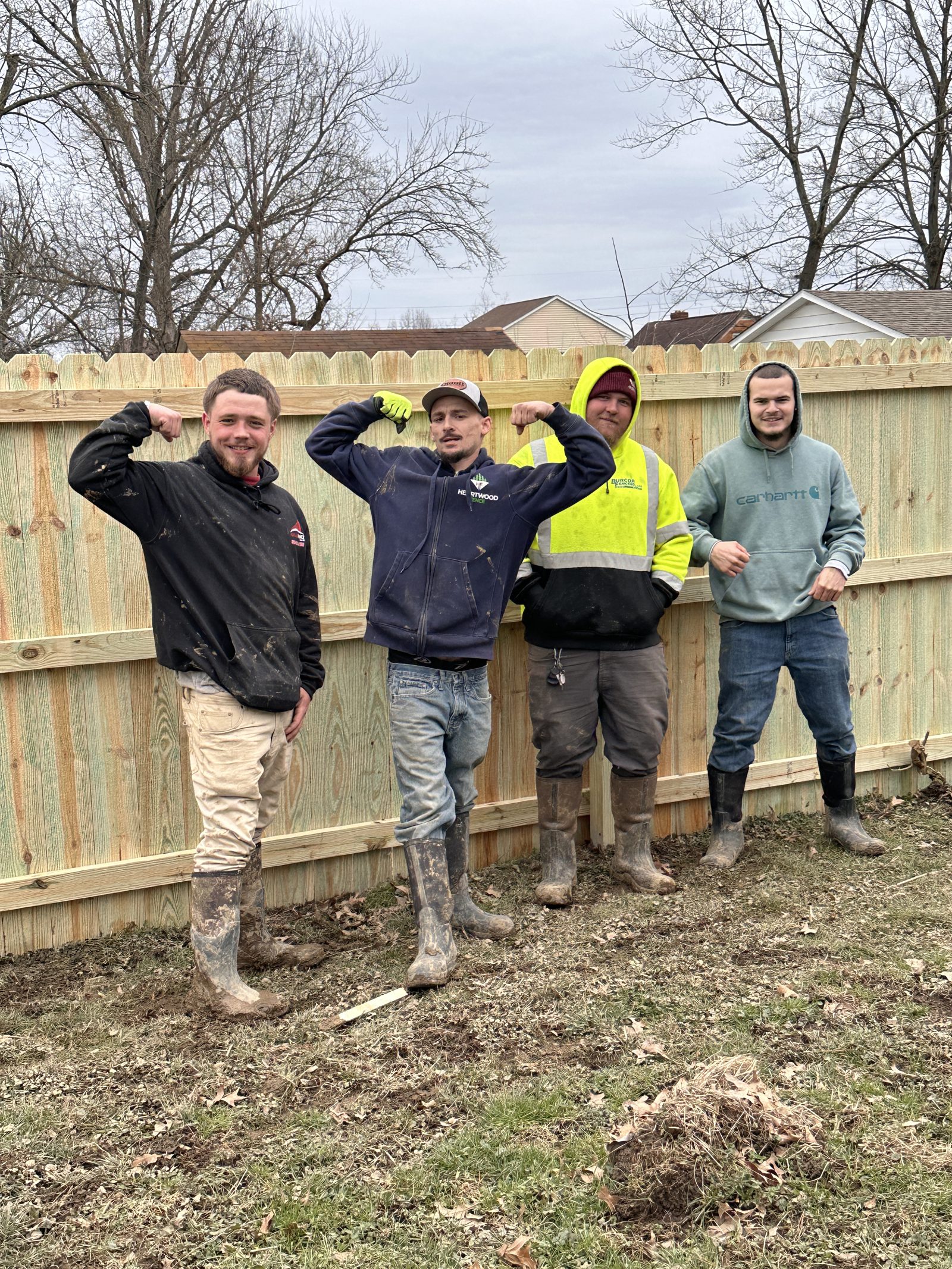 Heartwood crew relaxing on a finished wood privacy fence line