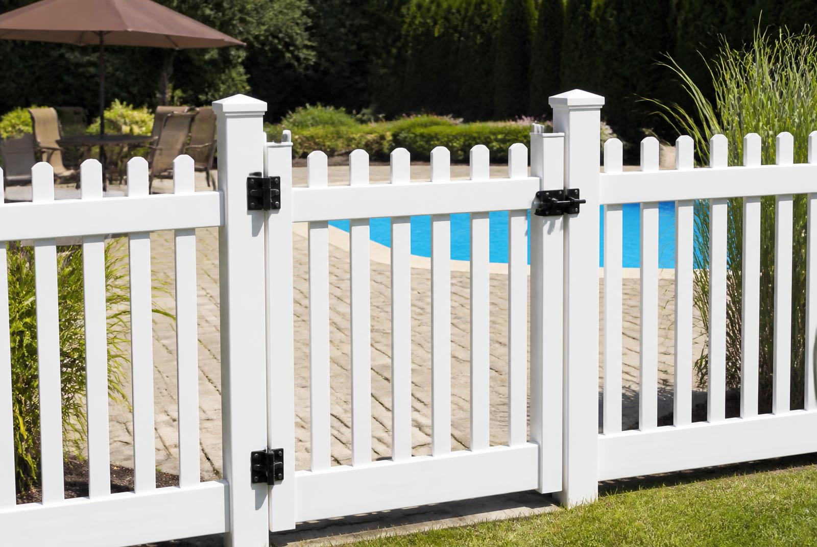 White picket pool fence with a self latching gate