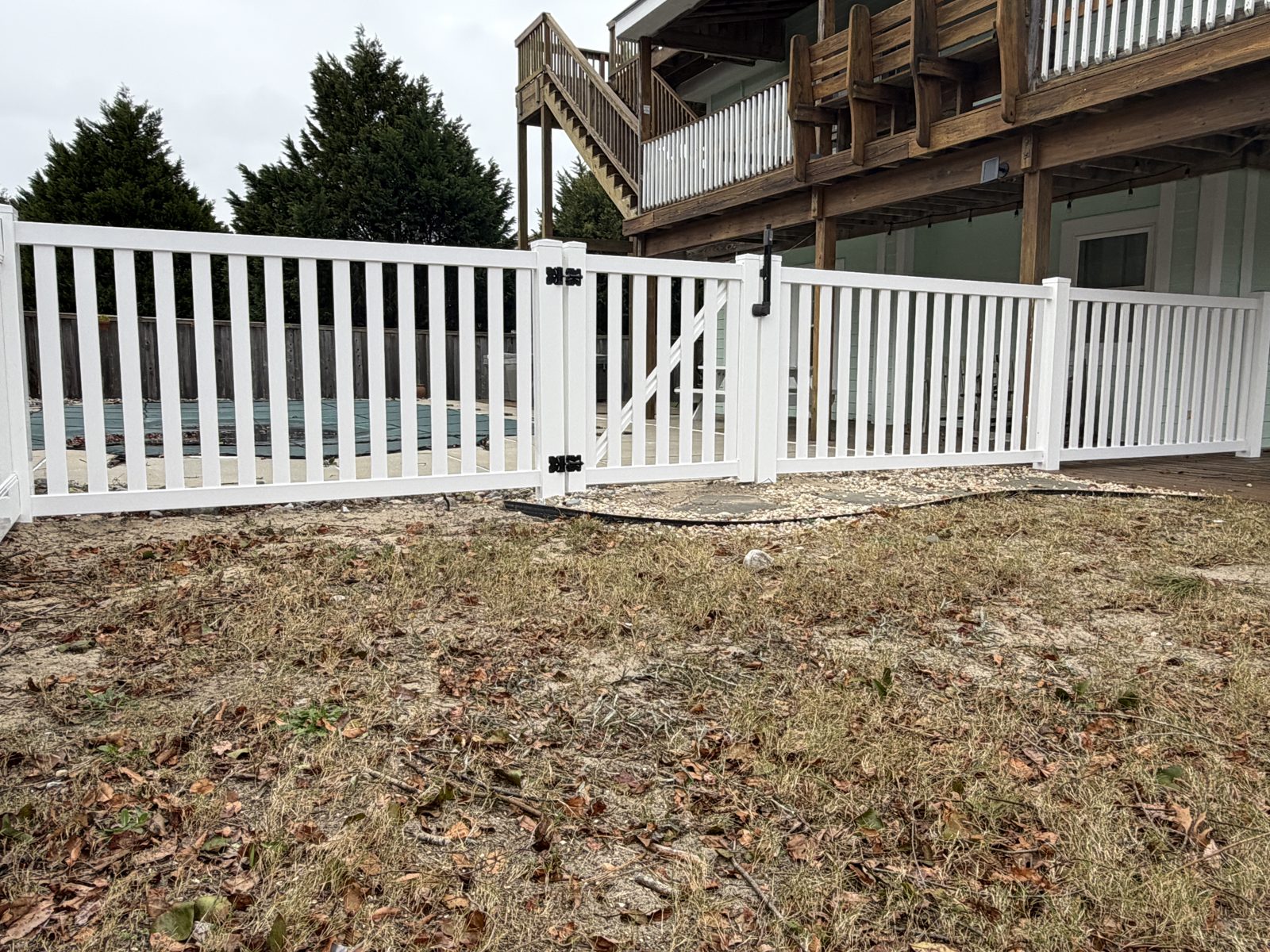 White vinyl picket fence in front of a home