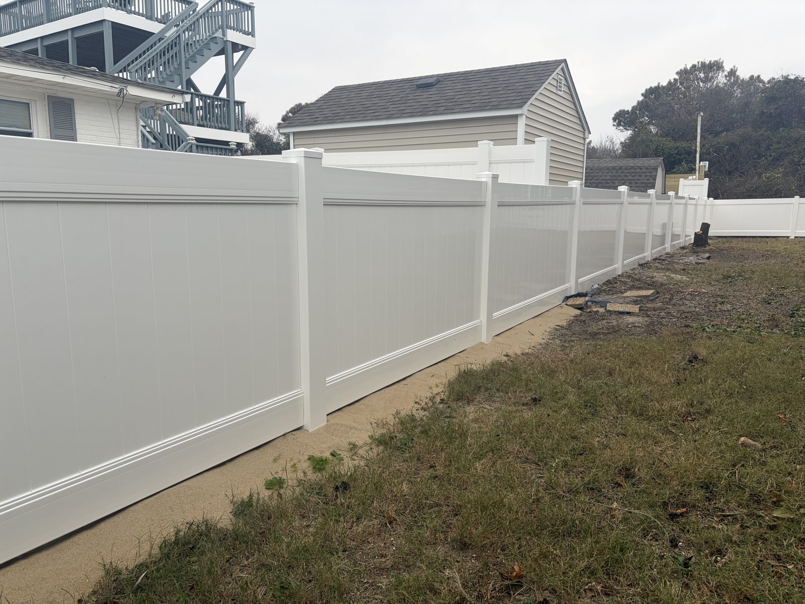 White vinyl privacy fence along a wide side yard