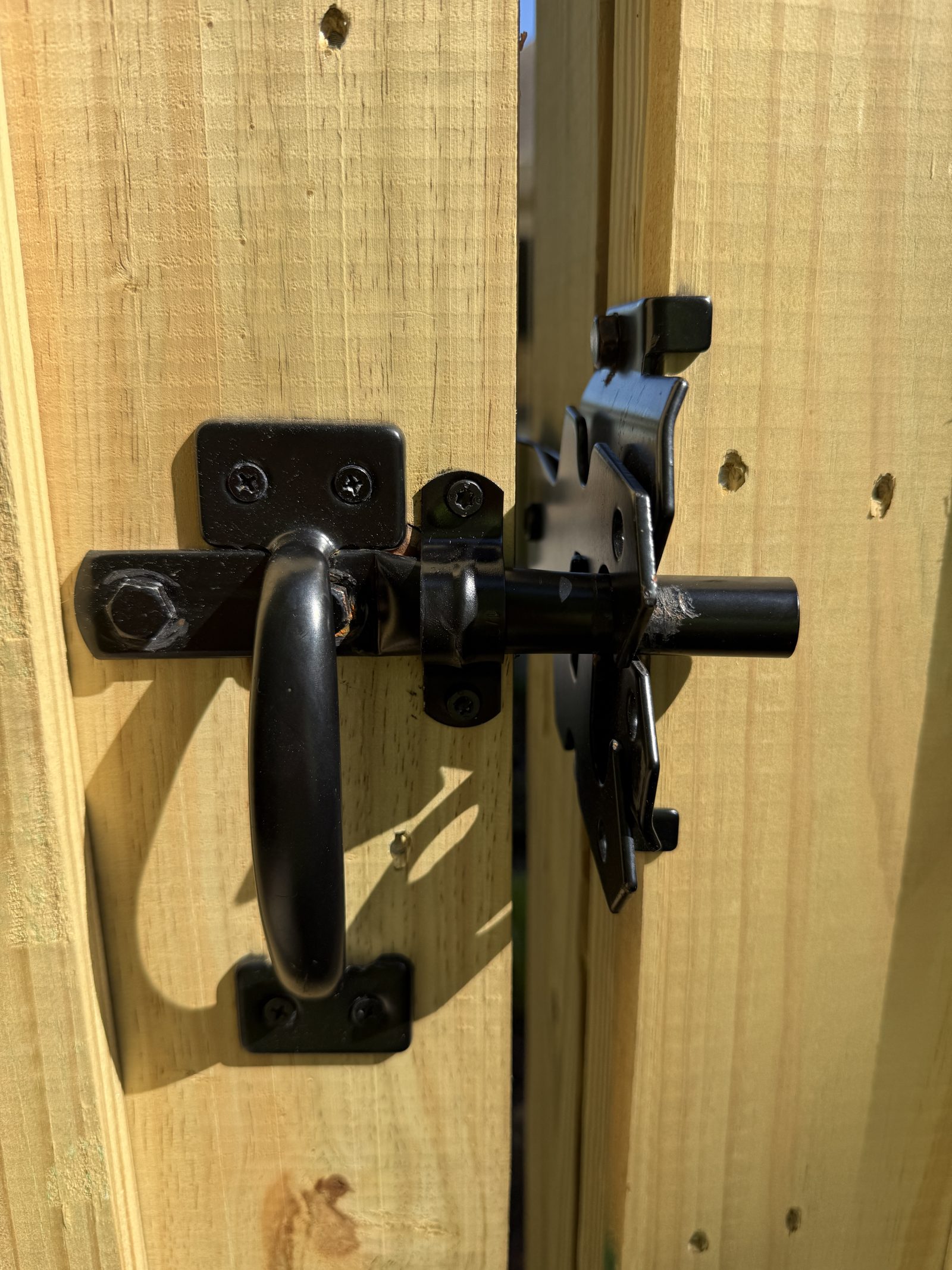 Black latch hardware on a wood fence gate